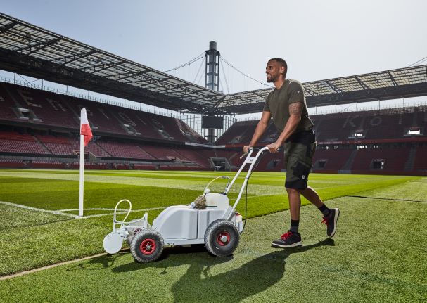 Ein Greenkeeper im Rheinenergiestadion trägt Arbeitskleidung mit UV-Schutz.